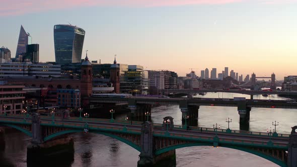 Rising crane aerial shot over Thames river bridges Central London Canary Wharf beautiful sunrise alt