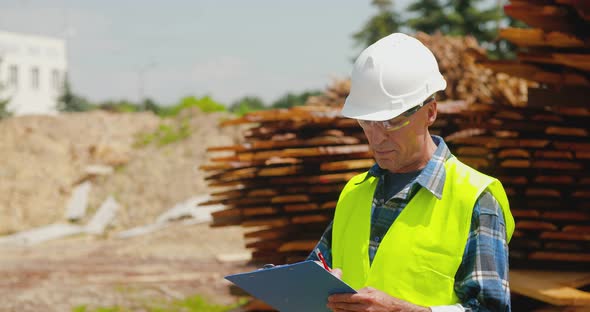 Male Worker Examining Plank's Stack alt