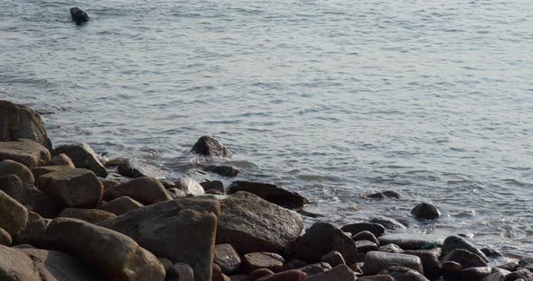 Sea wave on rock stone at sunset alt