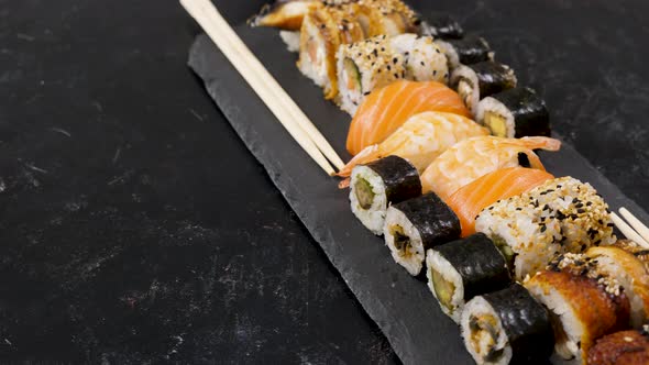 Rolls of Traditional Sushi on Black Stone Plate alt