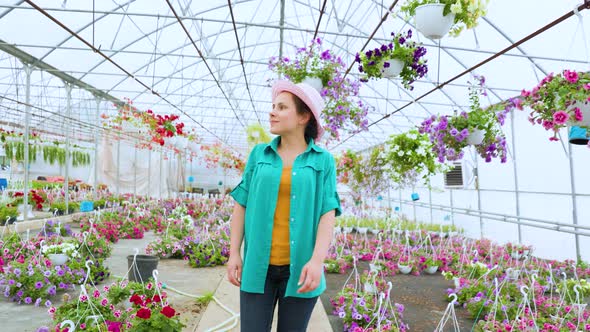 Sweet Girl Florist Walks in a Greenhouse with Flowers Carefully Examines Possessions Happy Smile alt