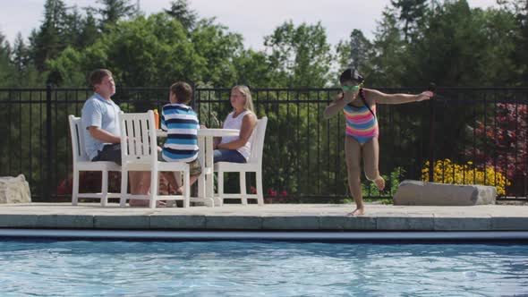 Girl jumping into backyard pool