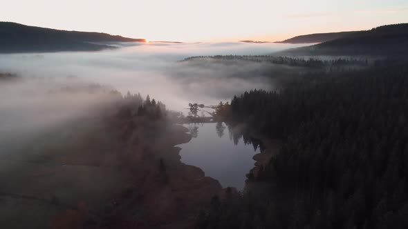 Aerial view of sunrise with fog above lake Schluchsee, Germany alt