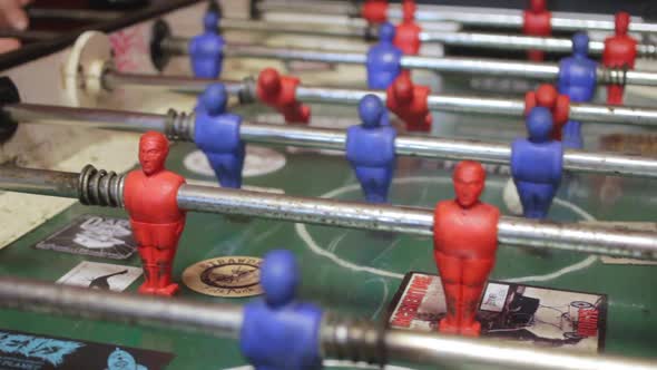 Close-up shot of people playing an old vintage game of fussball. alt