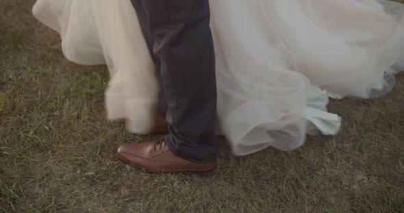 Female and male feet. The legs of the bride and groom walk in the park alt