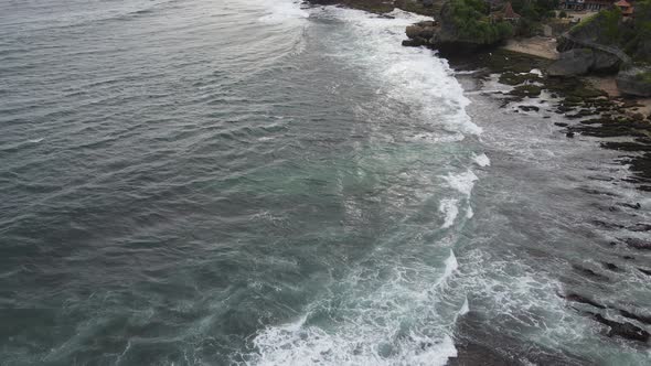 Aerial view of tropical beach in Gunung kidul, Indonesia with green and rocky cliff. alt