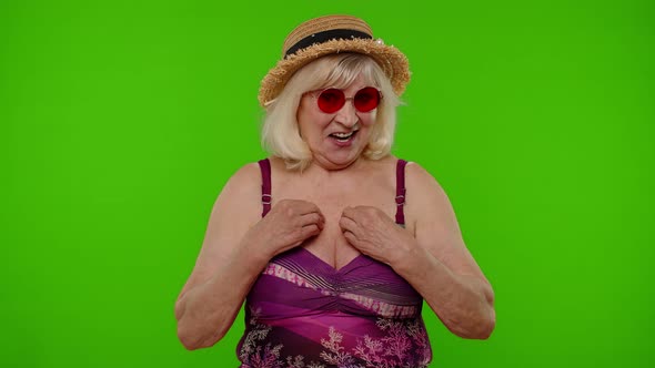 Mature Woman Traveler Pointing Herself Smiling Pleased Satisfied with Own Beauty and Achievements alt