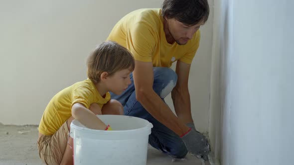 A Young Man and His Son are Doing a Walls Renovation in Their Home alt