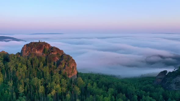Aerial Hyperlapse of a Rocky Peak in the Fog at Dawn