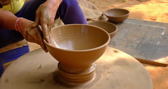 Skilled Hands of Potter Shaping the Clay on Potter Wheel and Sculpting Clay Pot Jar. Shilpagram alt