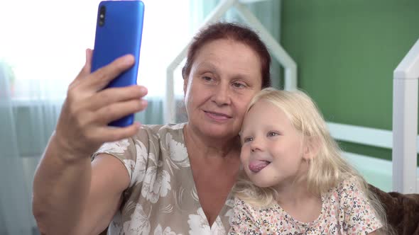Happy Grandmother and Granddaughter Girl Take Selfie By Smartphone alt