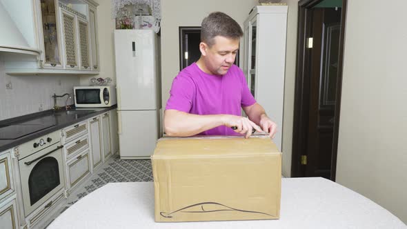 a Man Opens a Box with an Electric Car Charger alt