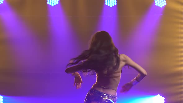 Girl in a Green Shiny Oriental Costume Performs Classical Belly Dance, Shot in a Dark Studio  alt