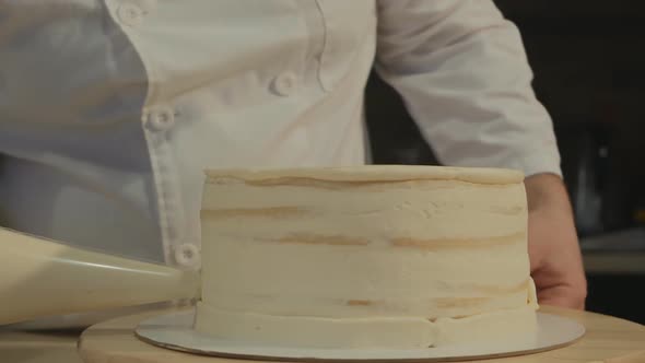 Man Pastry Chef in White Clothes Creates the Shape of the Cake