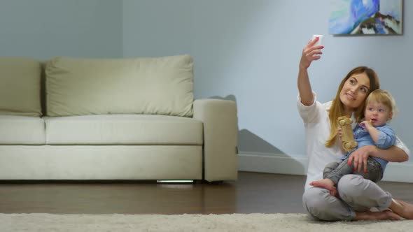 Lovely Mother Taking Selfie with Baby alt