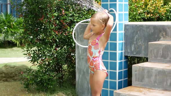 6 Year Old Girl in a Swimsuit Takes a Shower After Swimming in the Pool Resort in Thailand