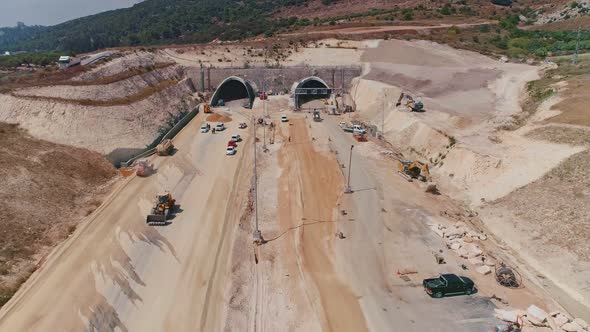Aerial footage of large highway construction project with tunnels and bridges alt