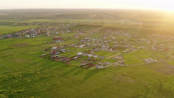 Drone flying above fields and village