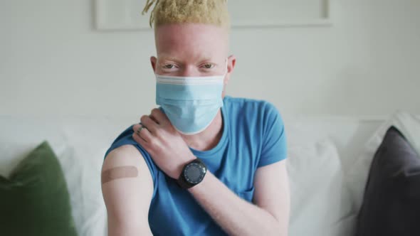 Happy albino african american man with dreadlocks and a plaster after vaccination alt