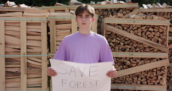 Outdoor of Men Activist with Save the Forest Ecology Poster. In Background Chopped Trees alt