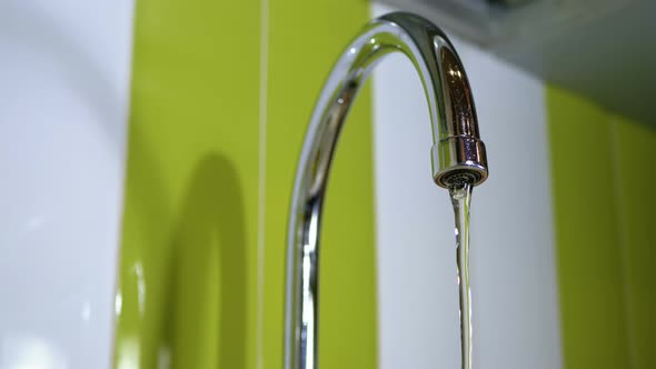 Water Running From the Tap Into a Sink alt