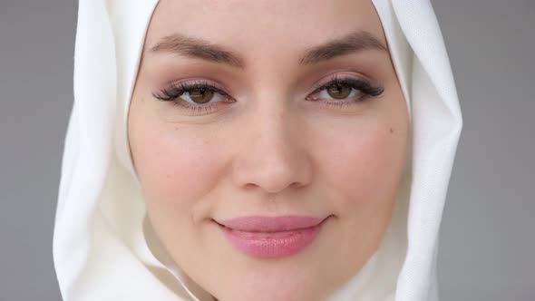 Closeup Face of Muslim Woman Wearing Hijab is Looking at Camera and Smiling alt