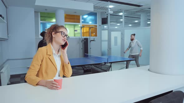 Businesswoman Talking on Phone During Coffee Break alt