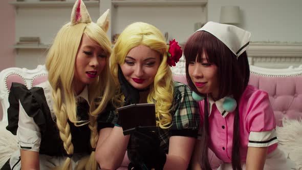 Cheerful Pretty Multiethnic Women in Cosplay Costume Viewing Old Photos alt