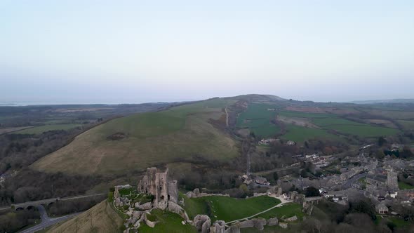 Aerial forward over Corfe Norman castle remains and surrounding landscape, Dorset county in England alt