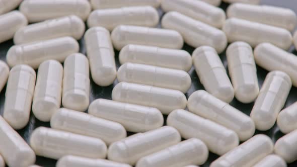 Looped Spinning Full Frame Macro Medical Background of White Drug Pill Capsules