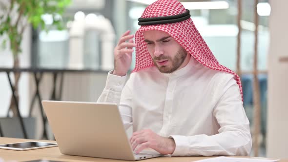 Stressed Arab Businessman with Laptop Having Headache in Office alt