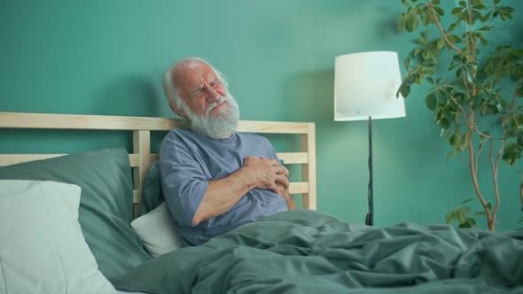 Elderly Man Holding His Chest With Both Hands He Has Difficulty Breathing alt