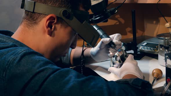 Goldsmith Is Processing a Ring with a Jewel. Jeweler Working Jewelry alt