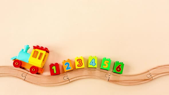Stop Motion Animation Kids Toy Train with Numbers on Toy Wooden Railway on Yellow Background alt