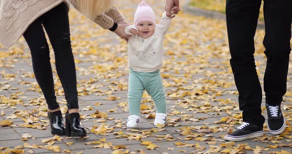 Happy Baby Learning To Walk in Autumnal Park