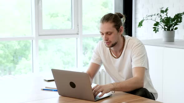 Side view handsome young businessman in eyewear working with computer remotely alt
