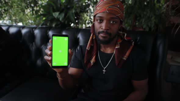 AfricanAmerican Man Showing Green Screen on Smartphone