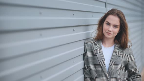 Portrait of a Young Business Girl Against a Wall on the Street alt