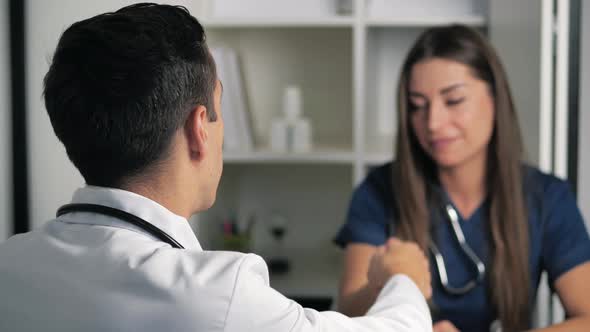 Smiling Female Professional Doctor Handshakes Male Doctor Agree to a Deal alt
