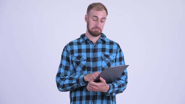 Happy Bearded Hipster Man Reading on Clipboard and Giving Thumbs Up alt