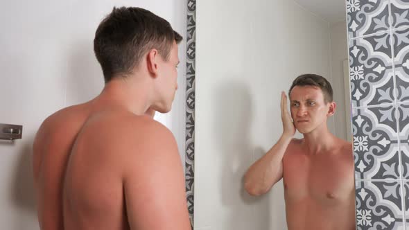Handsome Guy with Bare Torso Looks at Sunburned Face alt