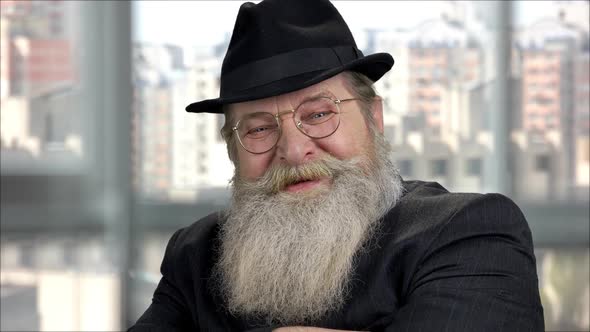 Closeup Portrait of an Old Bearded Smiling Man with Black Hat and Suit alt