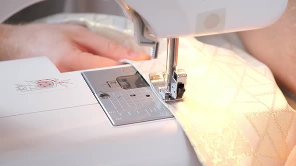 A Man Sews Clothes on Sewing Machine