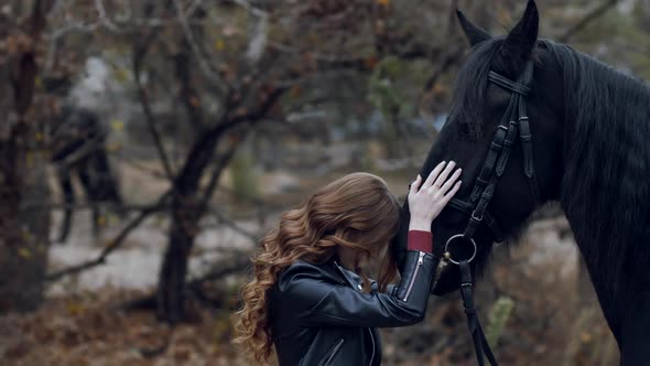 Beautiful Young Woman Stroking a Horse and Posing Outdoors alt