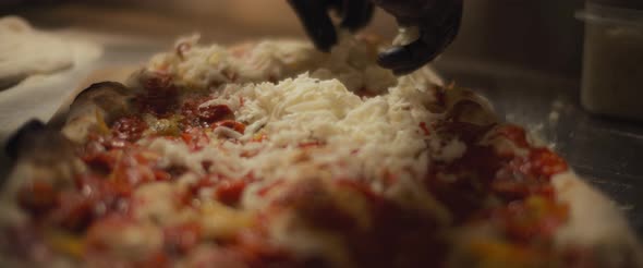 Chef spreading a mozzarella cheese over a traditional al taglio pizza. Slow motion. alt