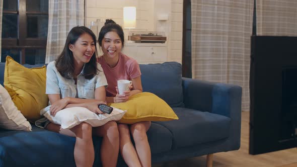 Asian female lover feeling happy funny moment looking drama entertainment together on sofa