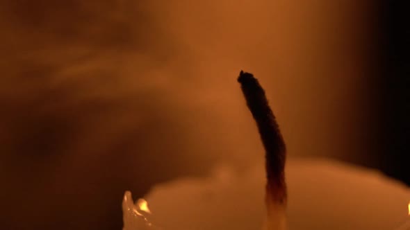 Macro view of extinguishing a candlelight by blowing it out in slow motion