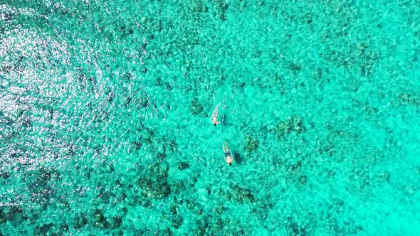Young couple swim and snorkel on clear water of turquoise shallow lagoon, watching beautiful rocks a alt