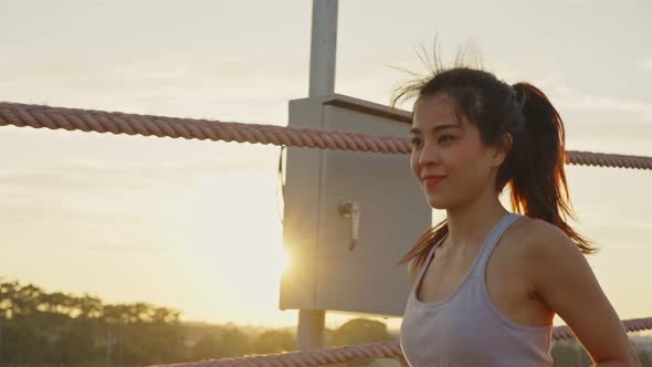 Asian young beautiful woman running for health in the evening sunset on street in public park. alt