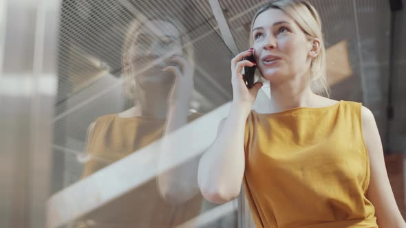 Cheerful Blonde Businesswoman Having Mobile Phone Conversation alt